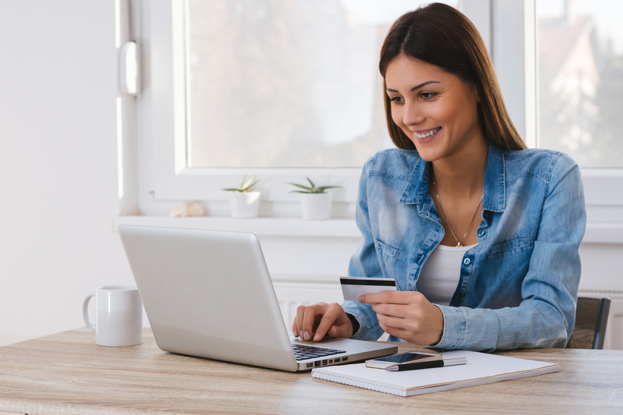 A happy woman paying online with her credit card 