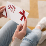 A young woman holding a Gift Card