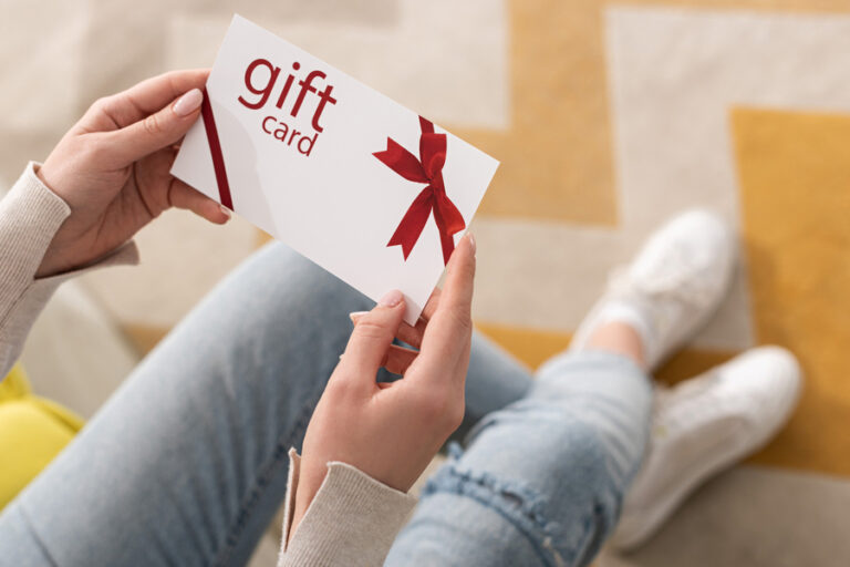 A young woman holding a Gift Card