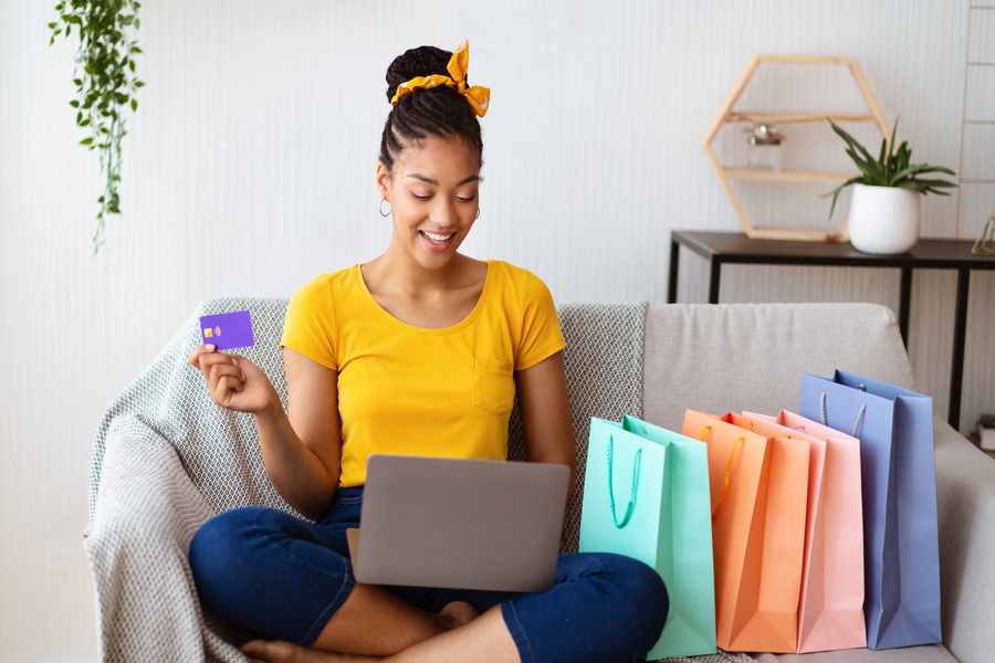 A happy woman shopping online with a Gift Card