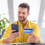 Young businessman making a micropayment over the phone