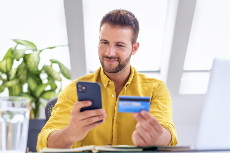 Young businessman making a micropayment over the phone