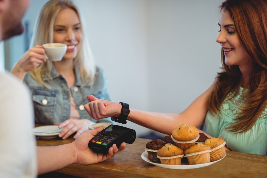 Customer with smart watch paying at cafe with Apple Pay