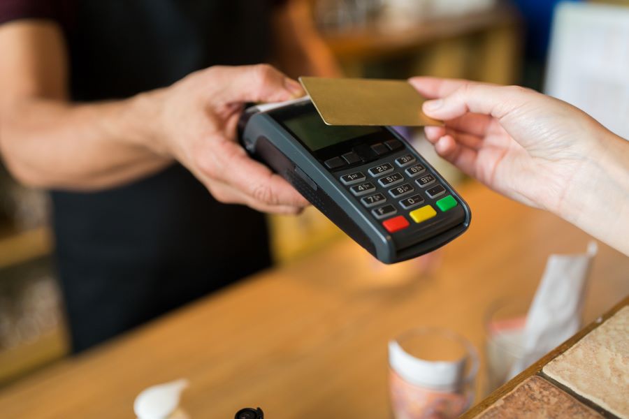 A hand of a man making a card payment on a POS terminal
