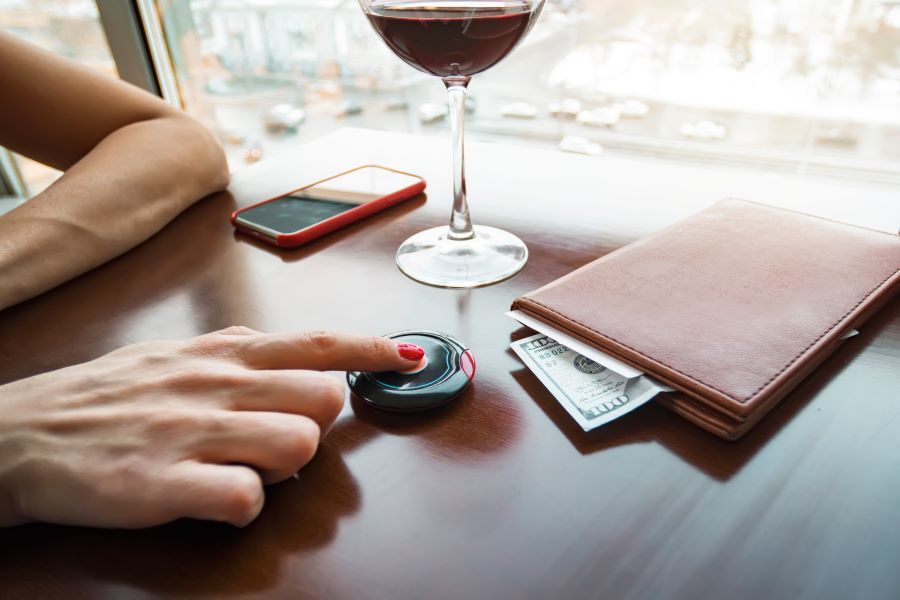 A woman leaving a tip in a bar with a glass of wine