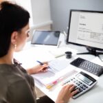 A businesswoman making a proforma invoice on a computer