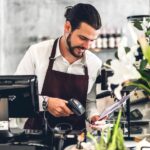 A barista working on a POS system at a cafe.