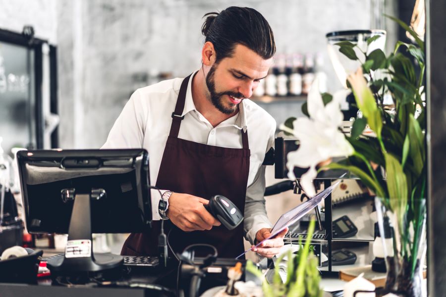 A barista working on a POS system at a cafe.