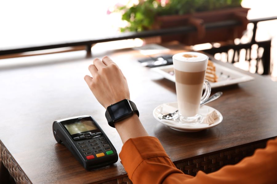 A woman paying with her watch on PDQ Machine.