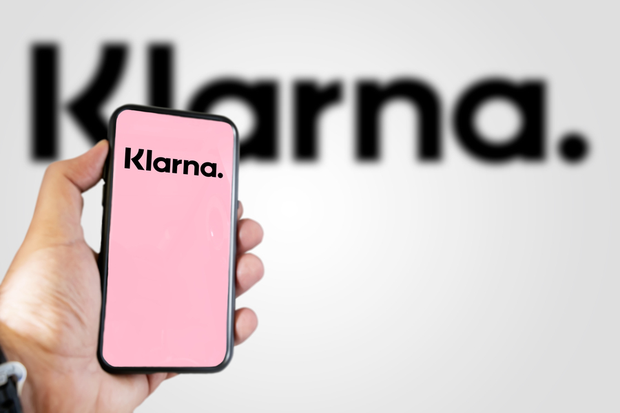 Hand holding a device with the Klarna mobile app on the screen