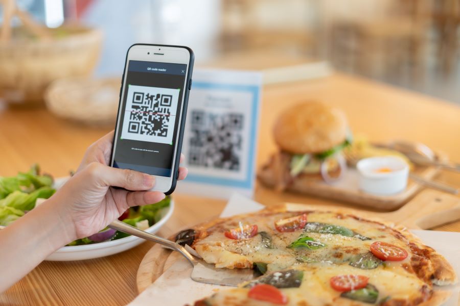 A woman paying with QR code in a cafe 