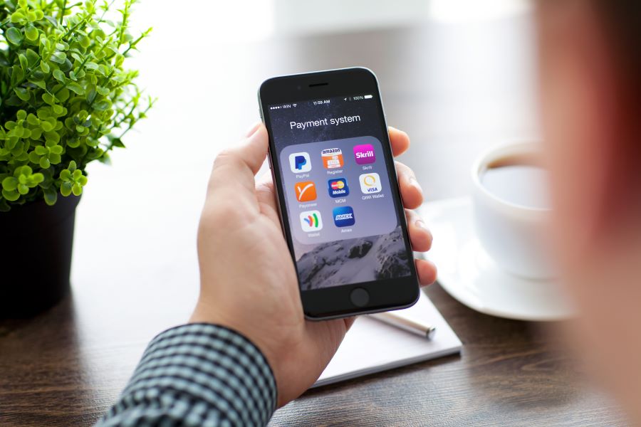 A businessman holding an iPhone with an iPhone Card Reader in hand.