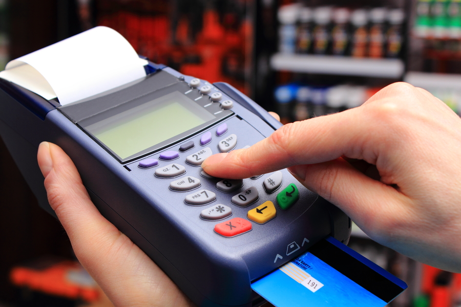 Woman holding a credit card payment machine, white paper coming out 
