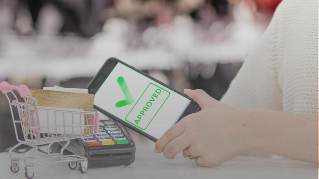 POS Terminal Payment Machine with Mobile Phone on Store Background