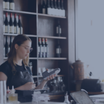 Female Cafe Worker Accepting Payment With Contactless POS machine