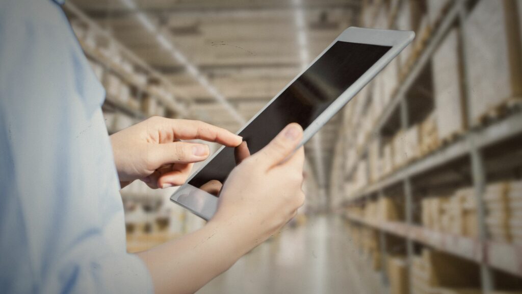 Staff using tablet with smart warehouse for Stock Management