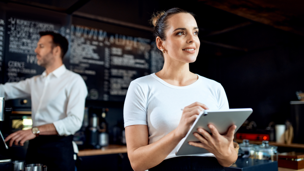 Portrait of restaurant manager standing with digital tablet at cafe