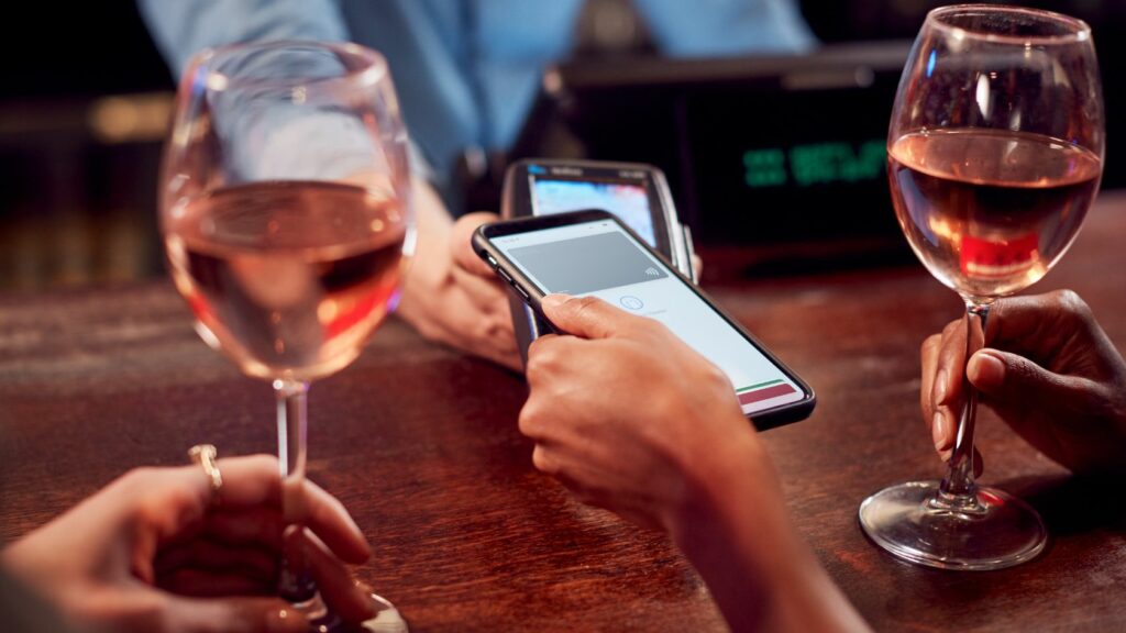 Close up of Woman Paying for Drinks at Bar Using Contactless App